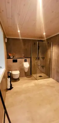 a bathroom with a shower and a toilet and a sink at Fantastisk feriehus på Tretten, Hafjell in Tretten