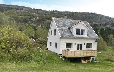 a white house in the middle of a field at Lovely Home In Sørbøvåg in Sørbø