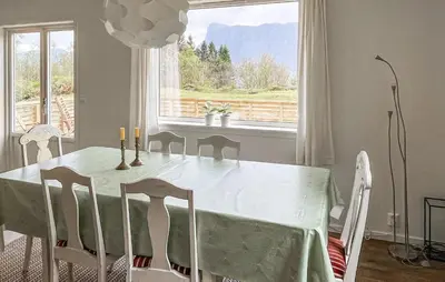 a dining room with a table and chairs and a window at Lovely Home In Sørbøvåg in Sørbø