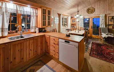 a kitchen with wooden cabinets and a sink and a table at Gorgeous Home In Tuddal in Tuddal