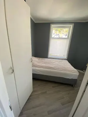 a small bedroom with a bed and a window at Flott leilighet med herlig utsikt in Ålesund
