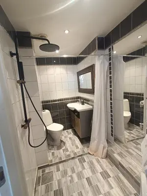 a bathroom with two toilets and a sink and a shower at Flott leilighet med herlig utsikt in Ålesund