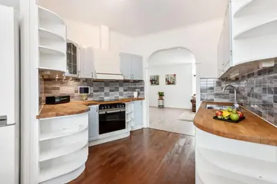 a kitchen with white cabinets and wood floors at Flott leilighet med herlig utsikt in Ålesund