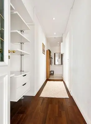 a hallway with white walls and a wooden floor at Flott leilighet med herlig utsikt in Ålesund
