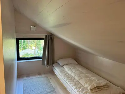 a bed in a small room with a window at Tyristua in Gjesval