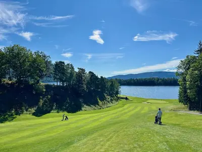 two people on a golf course near a lake at Tyristua in Gjesval