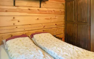a bed in a room with a wooden wall at Stunning Home In Todalen in Ålvundfjord