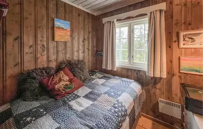 a bedroom with a bed in a wooden wall at Cozy Home In Sjusjøen With Sauna in Sjusjøen