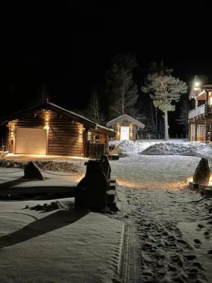 a person sitting in the snow in front of a cabin at Hytte Oppdal Så Klart in Oppdal