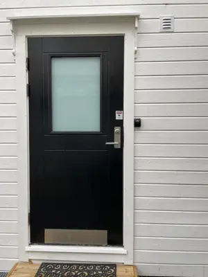 a black door with a window on a building at Koselig leilighet i sentrum in Ålesund
