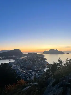 a view of a city and the ocean at sunset at Koselig leilighet i sentrum in Ålesund