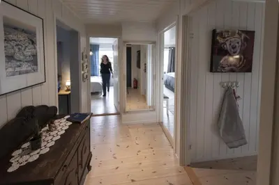 a woman walking down a hallway in a house at Koselig leilighet i sentrum in Ålesund