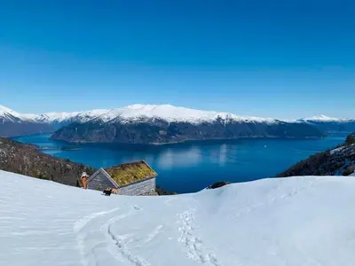 a building on top of a snow covered mountain at Seaside 3-bedroom Holiday home in Balestrand
