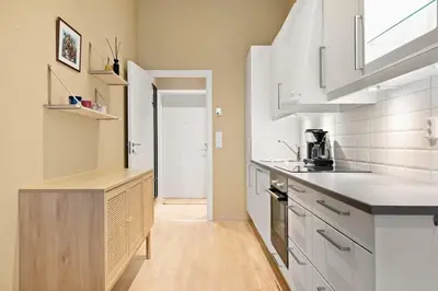 a kitchen with white cabinets and a counter top at Dining Apartments l Restaurants with sea I City Traveller & Workspace in Bergen