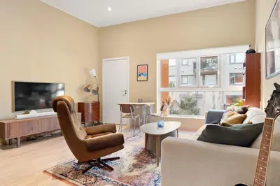 a living room with a couch and a tv at Dining Apartments l Restaurants with sea I City Traveller & Workspace in Bergen