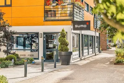 a store with a sun sign in front of a building at Dining Apartments l Restaurants with sea I City Traveller & Workspace in Bergen