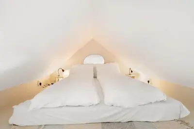 a bedroom with a white bed in a attic at Dinbnb Appartments l Live in a postcard ! l 300 m To Bryggen l Value! in Bergen