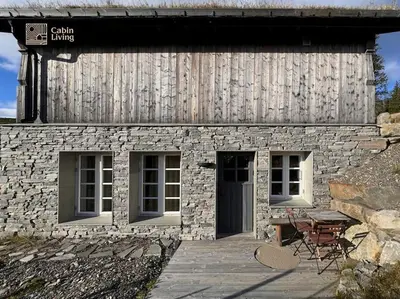 a stone building with a table and chairs in front of it at Modern apartment with ski in out in Hafjell in Hafjell