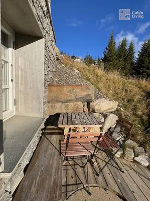 a bench sitting on a deck next to a building at Modern apartment with ski in out in Hafjell in Hafjell