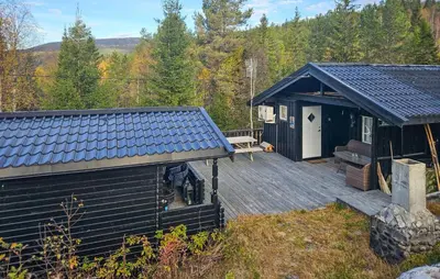 a cabin with a wooden deck with a bench on it at 3 Bedroom Amazing Home In Eggedal in Eggedal
