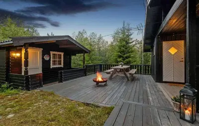 a wooden deck with a picnic table and a fire pit at 3 Bedroom Amazing Home In Eggedal in Eggedal