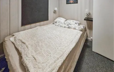 a bedroom with a large bed with a blanket on it at 3 Bedroom Amazing Home In Eggedal in Eggedal