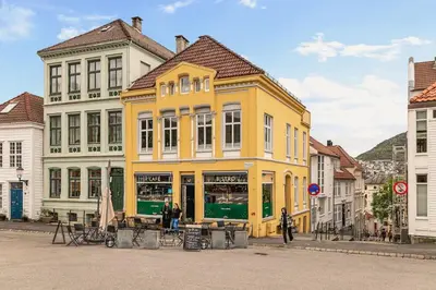 a yellow building in the middle of a street at Dinbnb Appartments l Traditional bergenshouse I Charming I Familiy in Bergen
