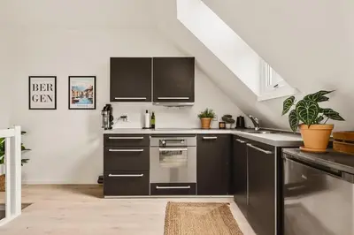 a kitchen with stainless steel appliances and a staircase at Dinbnb Appartments l Traditional bergenshouse I Charming I Familiy in Bergen