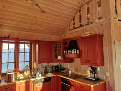 a kitchen with red cabinets and a counter top at Høyfjellshytte in Flå