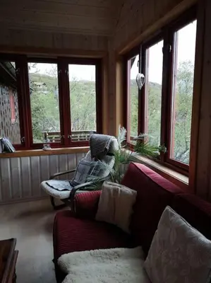 a living room with a couch and some windows at Høyfjellshytte in Flå