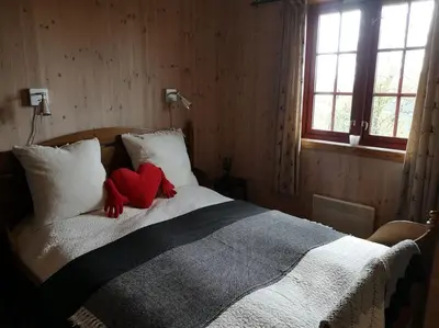 a bedroom with a bed with a red stuffed animal on it at Høyfjellshytte in Flå