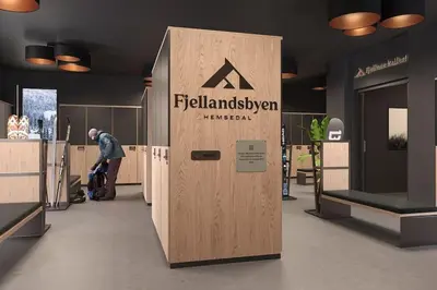 a man standing next to a wooden door in a room at Ski-in ski-out - Hemsedal Fjellandsbyen in Hemsedal