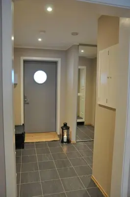 a hallway with a room with a door and a tile floor at Leilighet sentralt på Sjusjøen, 11 sengeplasser in Ringsaker