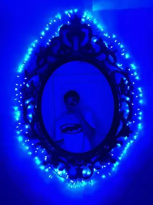a man in a mirror with blue lights at Top Floor Apartment Trondheim in Trondheim