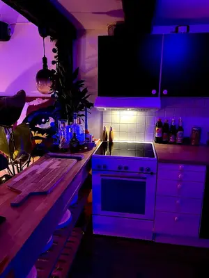 a kitchen with a stove and a purple lighting at Top Floor Apartment Trondheim in Trondheim