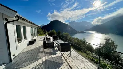 a balcony with benches and a view of a lake at Chalet with amazing fjord view in Lingåsen in Valldal