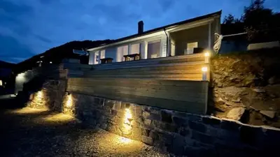 a house with lights on the side of it at Chalet with amazing fjord view in Lingåsen in Valldal