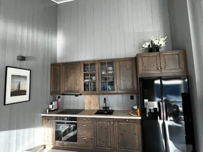 a kitchen with wooden cabinets and a stainless steel refrigerator at Chalet with amazing fjord view in Lingåsen in Valldal