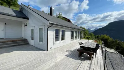 a building with a deck with a bench on it at Chalet with amazing fjord view in Lingåsen in Valldal