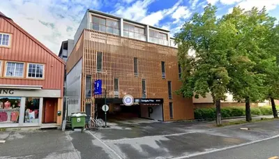 a building on a street next to a tree at 2 Bedroom Apartment Located Downtown Trondheim in Trondheim