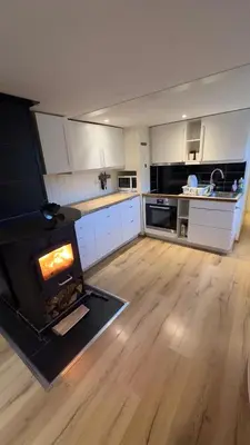 a kitchen with a fireplace in the middle of a room at Vassfjellet Home in Trondheim