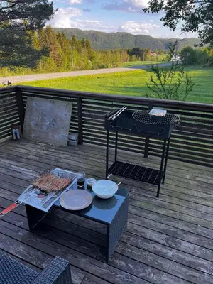 a picnic table on a deck with a grill at Vassfjellet Home in Trondheim
