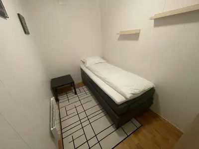 a small room with a bed and a tiled floor at Central 2 bedroom apartment in Lillehammer