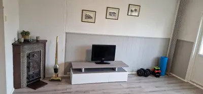a living room with a television on a table with a stove at Central 2 bedroom apartment in Lillehammer