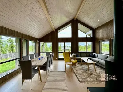 a living room with a table and a couch at Modern cabin Skeikampen with ski-in out cross country trails & great view in Aulstad