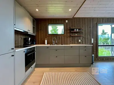 a kitchen with white cabinets and a sink at Modern cabin Skeikampen with ski-in out cross country trails & great view in Aulstad