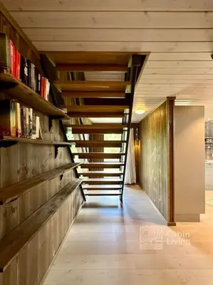 a hallway with stairs and bookshelves in a building at Modern cabin Skeikampen with ski-in out cross country trails & great view in Aulstad