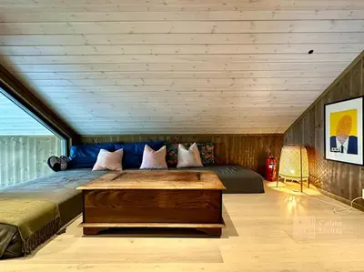 a bedroom with a large bed with a wooden ceiling at Modern cabin Skeikampen with ski-in out cross country trails & great view in Aulstad