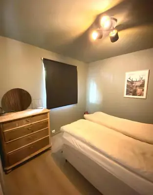 a bedroom with a bed and a dresser and a television at Lægdgrinda 11 in Trondheim