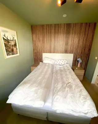 a large white bed in a bedroom with a wall at Lægdgrinda 11 in Trondheim